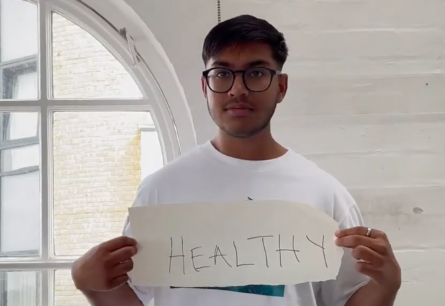 A student holds up a sign reading 'healthy'