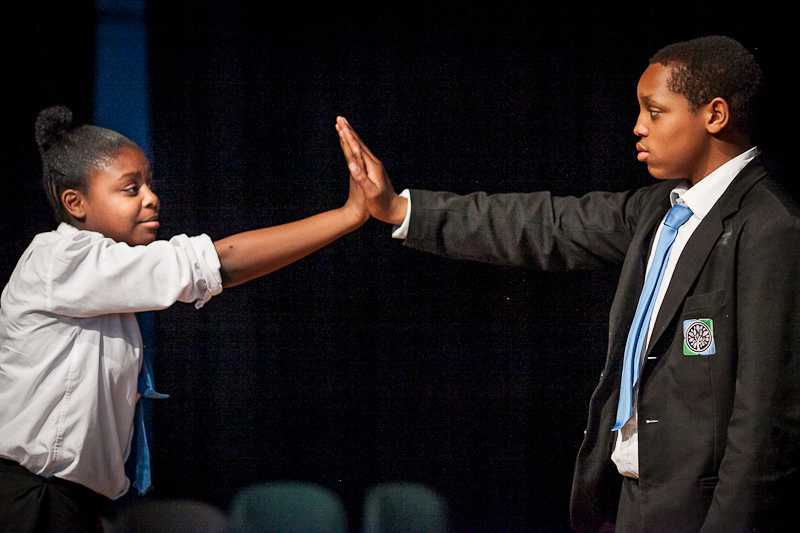 Two secondary school students reach out to each other in an activity