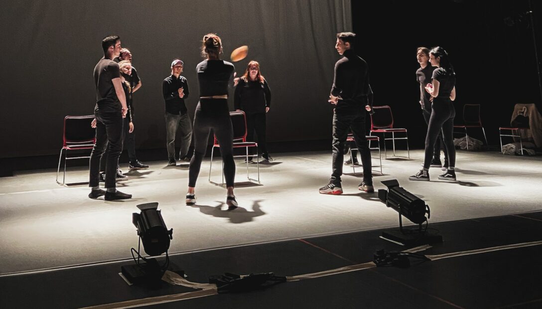 A drama warmup takes place in a rehearsal space